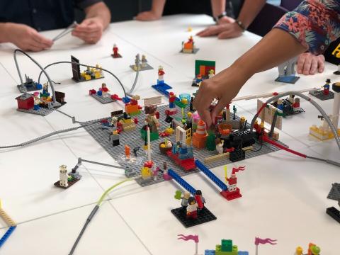 hand placing LEGO brick in shared model